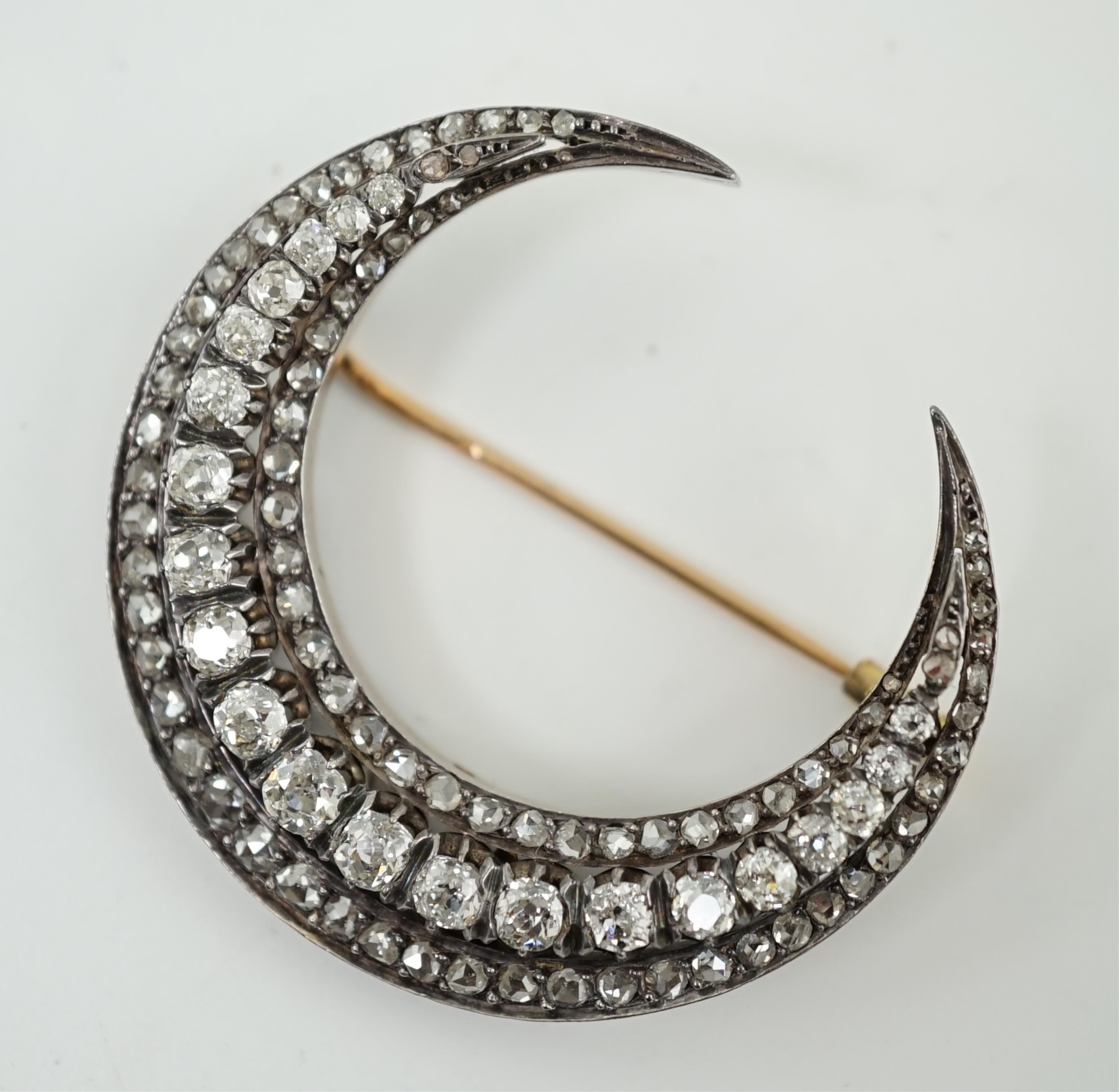A late 19th/early 20th century French 18ct gold and silver, old mine and rose cut diamond set three row crescent brooch